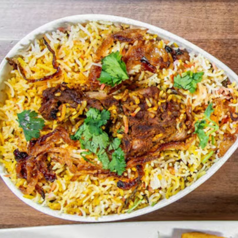 Aroma Indian Palace's chicken biryani, a flavorful rice dish with chicken, fried onions, and cilantro.